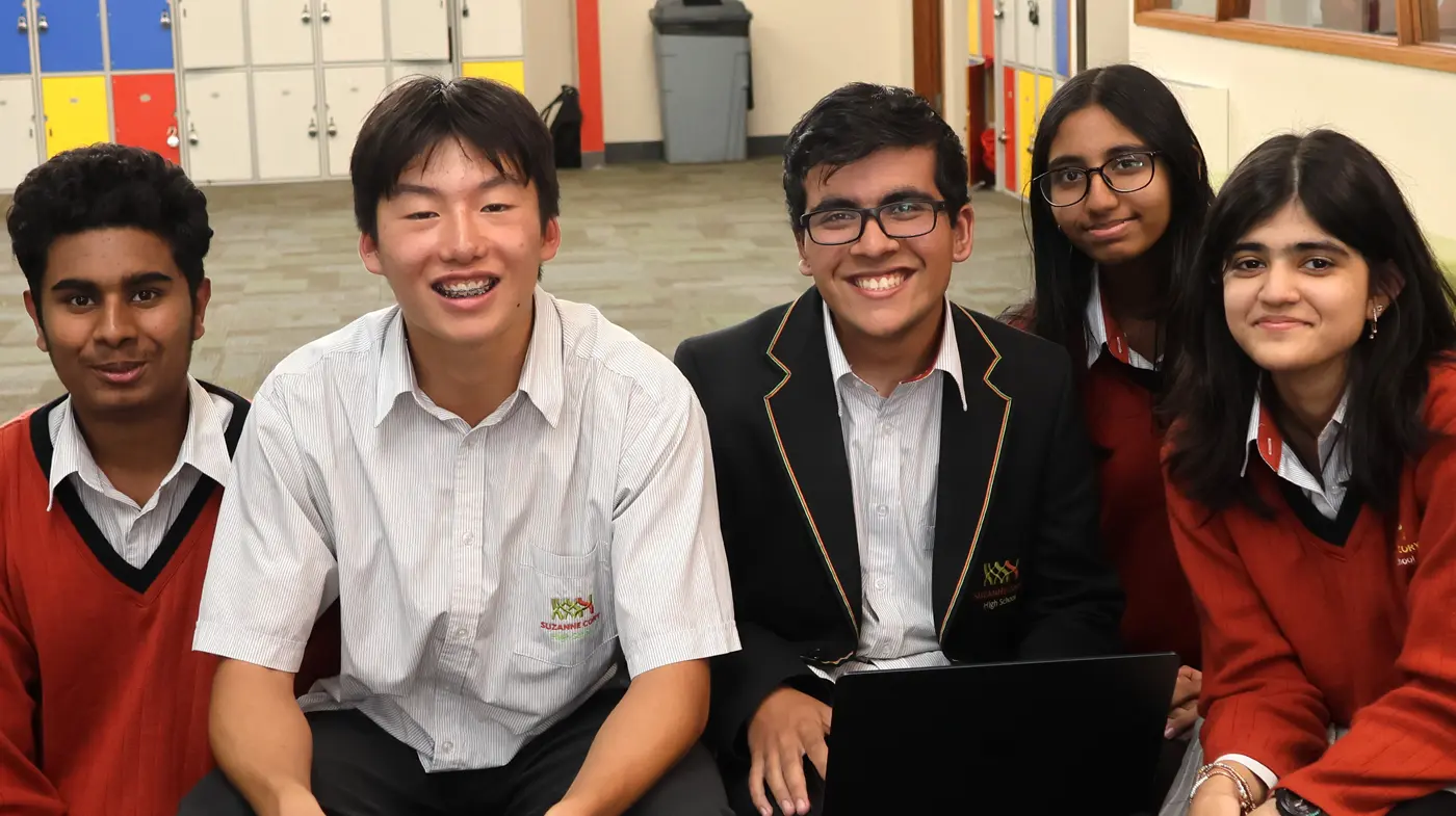 A group of students sitting together with a laptop