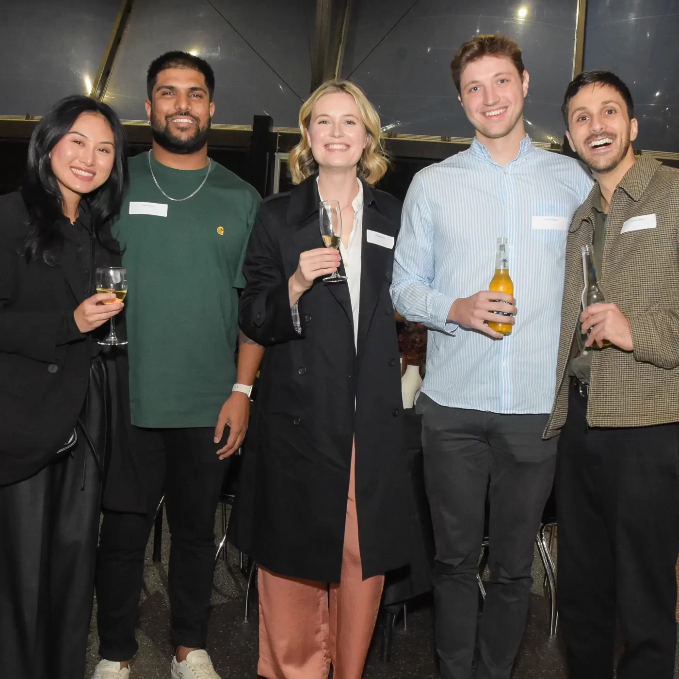 Five alumni with drinks in hand