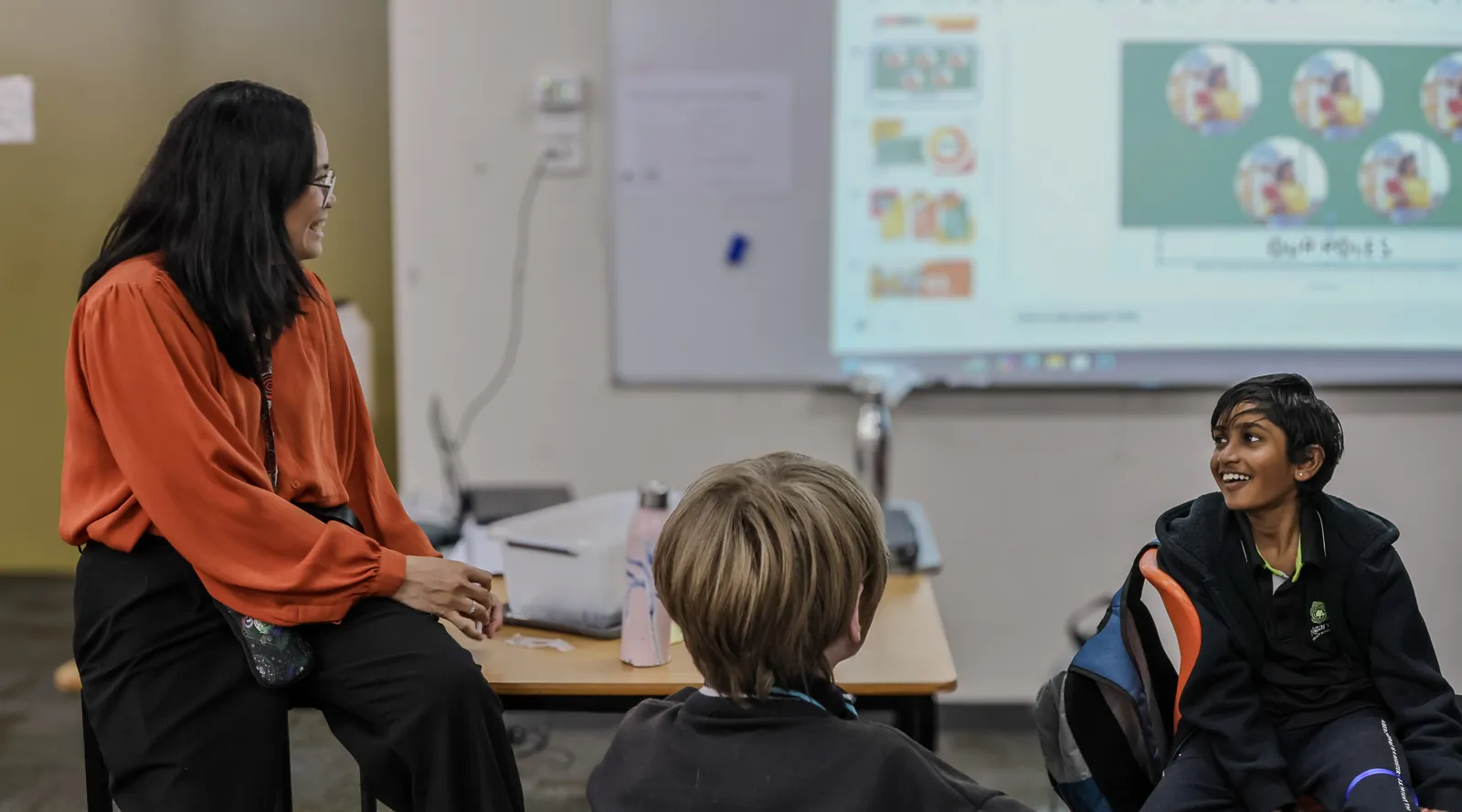Teacher talking to 2 young students