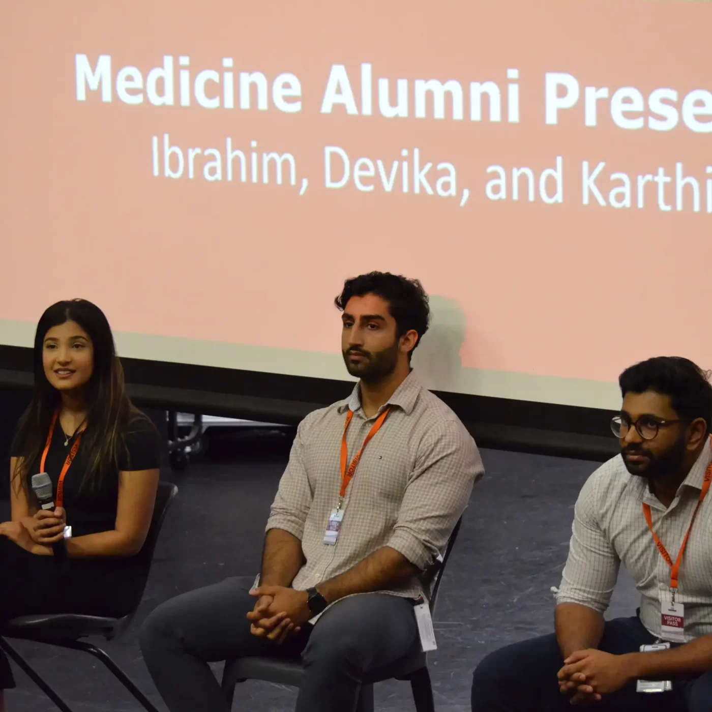 One female and two male medicine students with a microphone