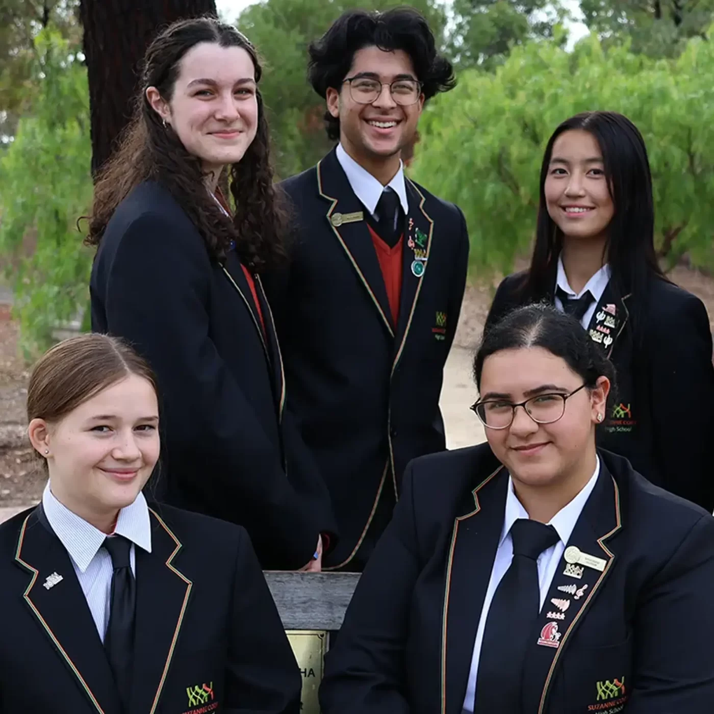 Five students in blazers looking at the camers